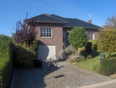 a brick house with a bike parked in the driveway at De Zilveren Helm in Halen