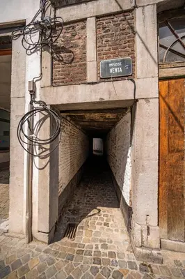a brick tunnel with a sign on the side of a building at L'atelier de Liège: Tranquillité & Effervescence in Liège