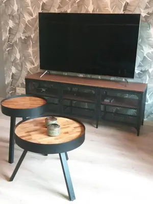 two tables with a television on a entertainment center at La Maison de Sidonie in Jalhay