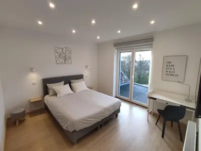 a bedroom with a bed and a desk and a window at Studio Citadelle - Chambres avec salle de bain indépendantes et cuisine partagée in Liège