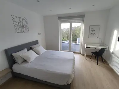 a bedroom with a bed and a desk and a window at Studio Citadelle - Chambres avec salle de bain indépendantes et cuisine partagée in Liège