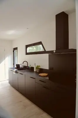 a kitchen with black cabinets and a sink at Sweet Valley Julia in Zutendaal