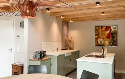 a kitchen with two sinks and a table at Sonnevijver Vijverdorp-Waterl in Bovenwezet