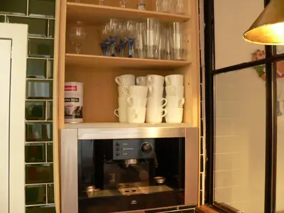 a cupboard with cups and a coffee maker at liège 4420 rue jean Jaurès 45 grande maison joyeuse avec terrasse 30m2 pour 8 personnes maximum in Saint-Nicolas