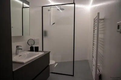 a white bathroom with a sink and a shower at Vakantiewoning Xalot in Tongeren
