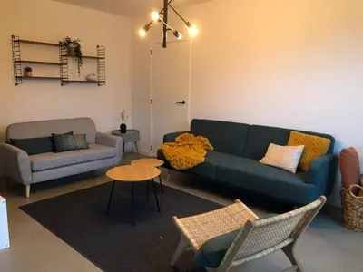 a living room with a blue couch and a table at Villa veld en velo in Bree