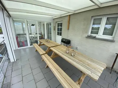 a large wooden table on the back of a patio at 8P 3B Cosy vacation home for 8 persons in Heers