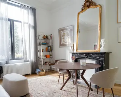 a living room with a table and a mirror at La Maison de Chestret in Liège