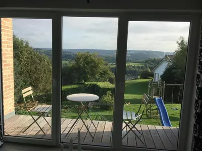 a window view of a deck with a table and chairs at Le temps d’une balade. in Olne