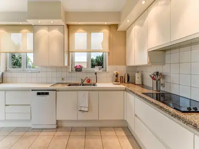a kitchen with white cabinets and a sink at Heers Retreat with Sauna in Heers