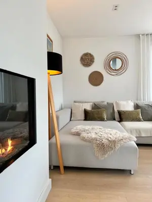 a living room with a couch and a fireplace at Ons Maashuisje in Maaseik