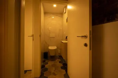a small bathroom with a toilet and a sink at Haspenhoeve Vakantiewoning in Herstappe