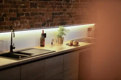 a kitchen with a sink and a counter with a light at Haspenhoeve Vakantiewoning in Herstappe