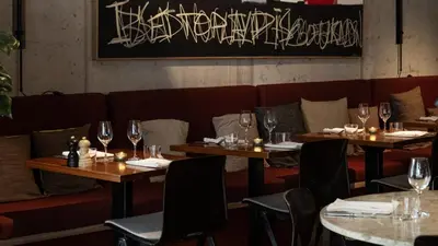 a restaurant with two tables with wine glasses at YUST Liege in Liège