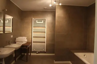 a bathroom with two sinks and a tub and a shower at Hoeve Luitenant Halleux in Linter