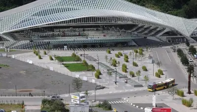 a bus is parked in front of a large stadium at La suite de lati in Liège