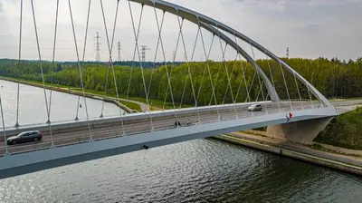 a bridge over a river with cars on it at EuroParcs Hoge Kempen in Zutendaal