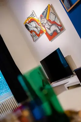 a room with a desk with a computer and posters on the wall at GITADIN - Deluxe Suite Valens - Historical Center in Liège