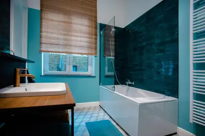 a blue bathroom with a tub and a sink at GITADIN - Deluxe Suite Valens - Historical Center in Liège