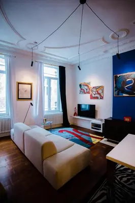 a living room with a couch and a television at GITADIN - Deluxe Suite Valens - Historical Center in Liège