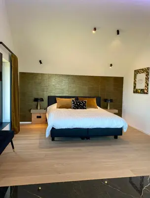 a bedroom with a large bed in a room at Le Clos du Verger in Aubel