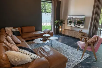 a living room with a leather couch and a table at In't Groene Woud in Peer