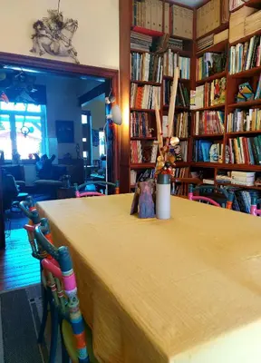a table in a room filled with books at L'Atelier Bed and Breakfast in Andrimont