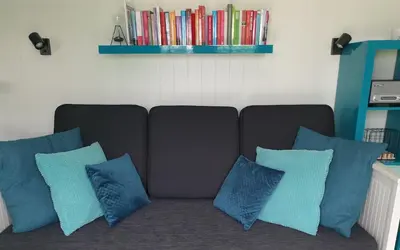 a couch with four blue pillows in a living room at Tijd voor jezelf en elkaar bij Me&We in Zutendaal