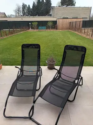 two black chairs sitting on a patio with a yard at VERADEMING in Bilzen