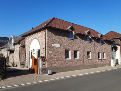 a brick building on the side of a street at Aan het Singelhof - Mirabelle -- 4 sterren -- met sunshower en tuin in Sint-Truiden