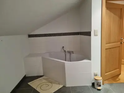 a white bath tub in a room with a door at SusBerg-1 & 2 in Pelt