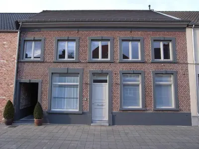 a brick building with windows and a white door at B&B Bianero in Peer