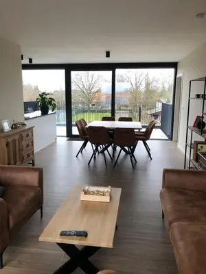 a living room with a table and chairs at Residentie Zeezicht in Eksel