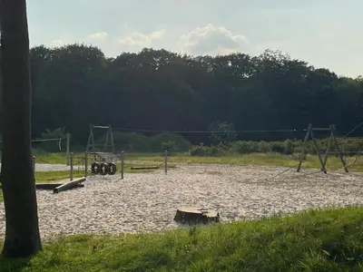 an empty playground with two swings and a swing at De Bosdreef - Hengelhoef - duplex met verwarmd openluchtzwembad in Houthalen-Helchteren