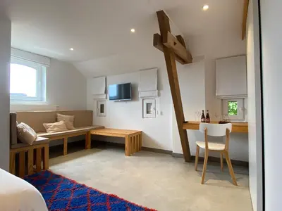 a room with a bed and a cross on the wall at Ô Macra B&B - Aubel, Pays de Herve in Aubel
