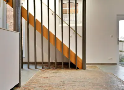 a hallway with a staircase with metal railings at Ô Macra B&B - Aubel, Pays de Herve in Aubel