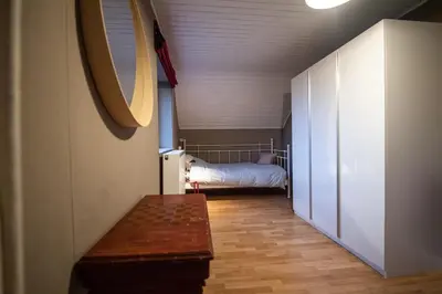 a hallway with a bed in a room with a table at Ô Macra House - Aubel, Pays de Herve in Aubel