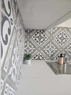 a room with a tile wall with two plants on it at Houten huisje tussen paarden in Nieuwerkerken