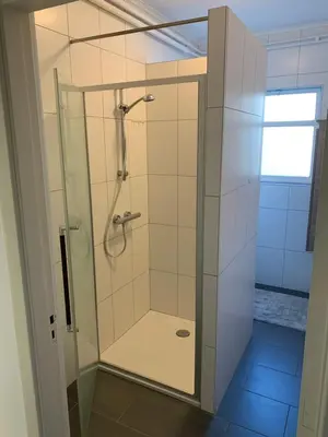 a shower with a glass door in a bathroom at De Lelie in Achel