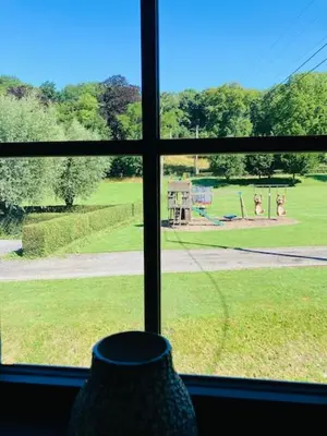 a window with a view of a field of grass at De Molenhoeve B&B in Voeren