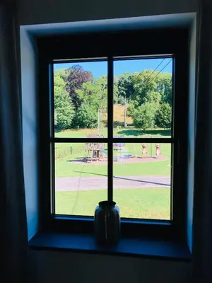 a window with a view of a park seen through it at De Molenhoeve B&B in Voeren