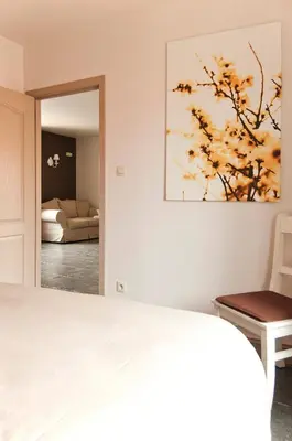 a bedroom with a bed and a painting on the wall at B&B De Fruithoeve in Hoeselt