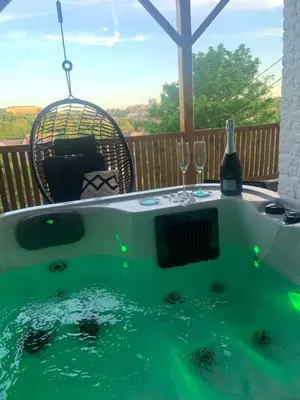 a hot tub with a bottle of wine and glasses at Suite Tino in Verviers