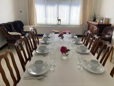 a dining room table with glasses and flowers on it at Vakantiewoning Wurfeldermolen in Maaseik