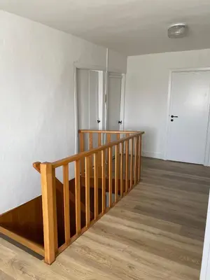 an empty room with a wooden staircase and a door at Vakantiewoning Wurfeldermolen in Maaseik