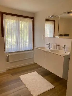 a bathroom with a sink and a mirror and a window at Vakantiewoning Wurfeldermolen in Maaseik