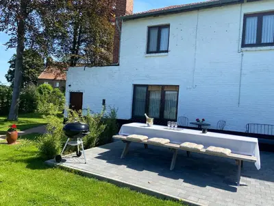 a barbecue grill and a bench in a yard at Vakantiewoning Wurfeldermolen in Maaseik