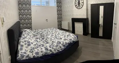 a bedroom with a bed with a blue and white comforter at Proche de tout lieux touristiques à Liège in Liège