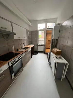 a large kitchen with a stove and a sink at Proche de tout lieux touristiques à Liège in Liège