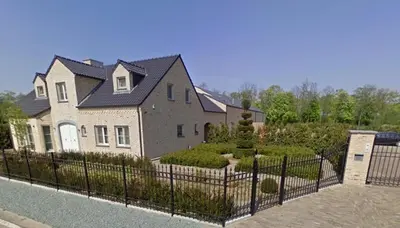 a large house with a fence in front of it at Susberg 4 in Pelt
